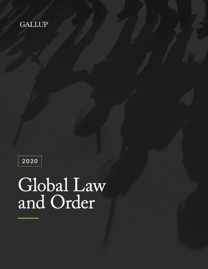 The feet of police force members are displayed with their shadow casting upside down on the cover of Gallup’s Global Law and Order 2020 report. There are also shadows of weapons. 