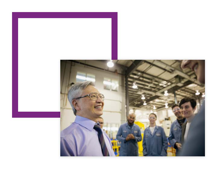 Image of warehouse workers talking over image of a purple square