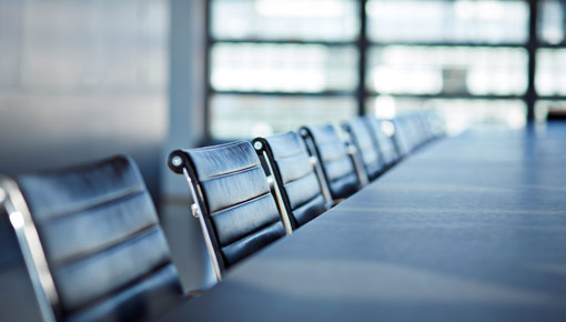 A closeup shot of chairs and a table in an empty boardroom