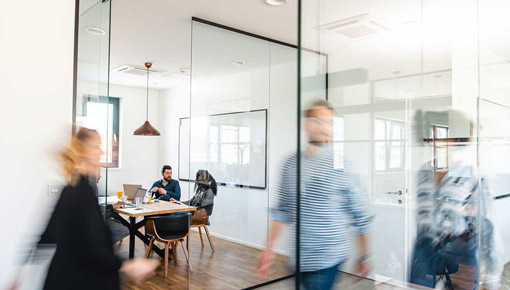 Blurred action shot of a busy office hallway with employees walking