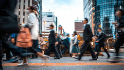 Group of people walk on busy city sidewalk in business district