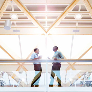 Two men talking on a balcony in an office building