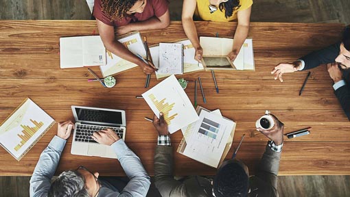 An overhead shot of several coworkers at a table in an office