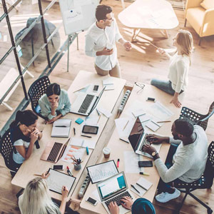 Group of employees working together at a table in a well lit office