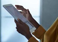 A pair of hands scroll on a tablet computer