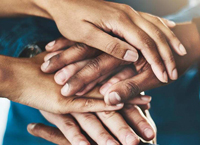 Overhead view of several hands clasping together