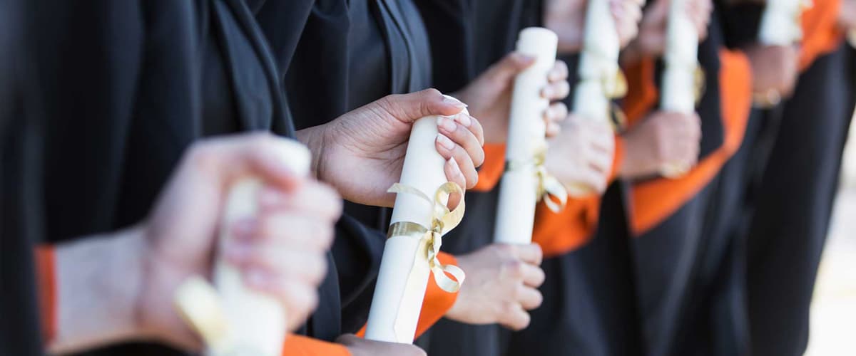 A group of graduates holding diplomas.