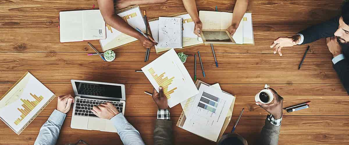 Overhead view of five people working at a table.