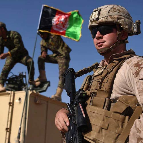 Armed soldier's standing around the flag of Afghanistan.