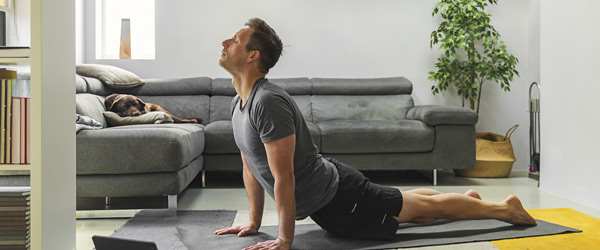 Man streching on mat in living room