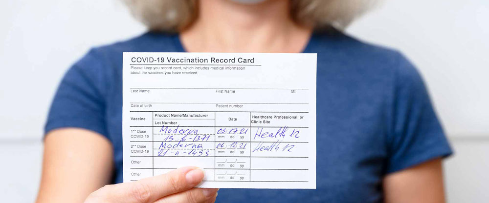 Woman holding up vaccination card.