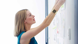 Business women hanging paper on white board