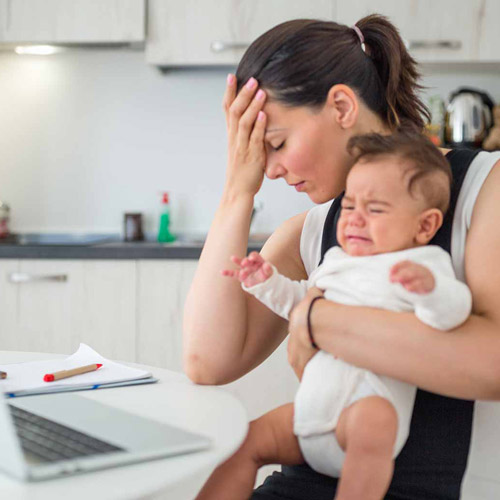 Frustrated woman holding a baby