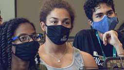 Three students wear face masks