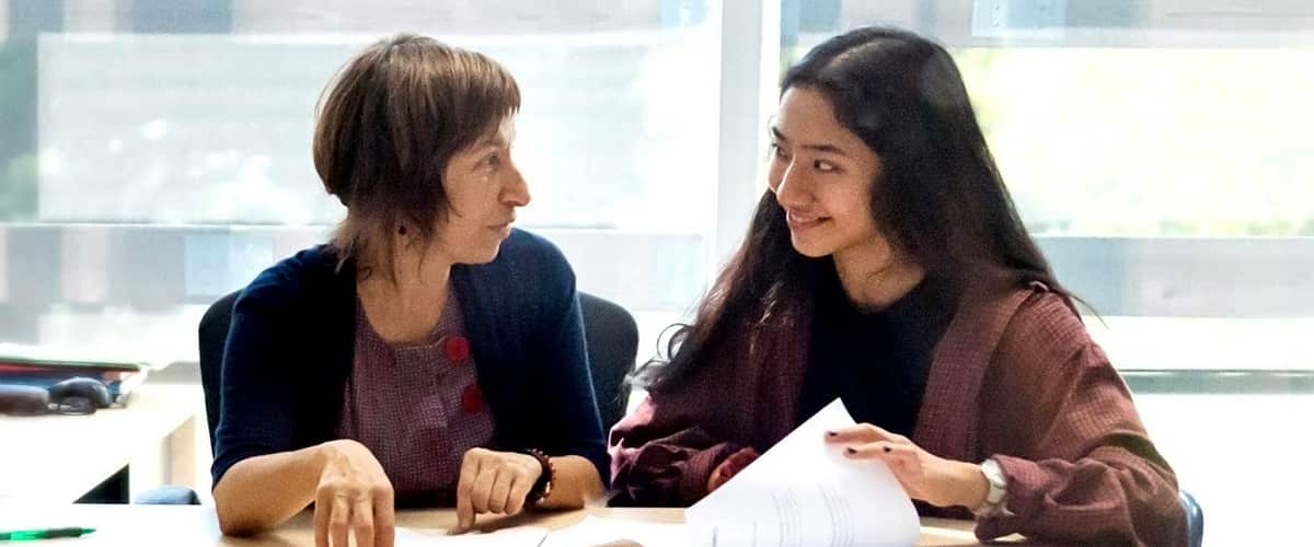 Two women sitting next to each other in an office setting