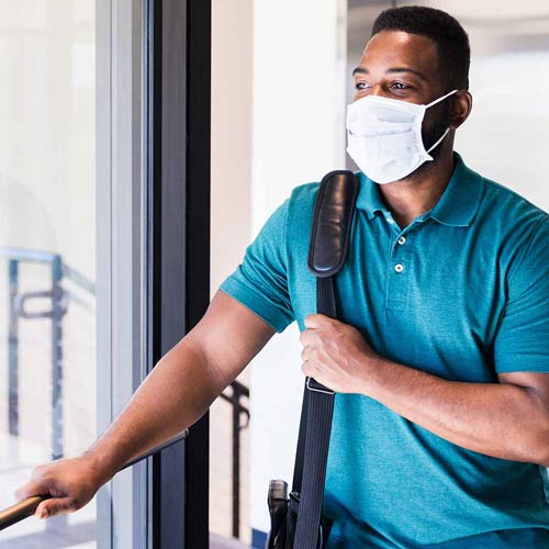 Man wearing a mask and carrying a messenger bag