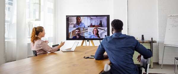 Two individuals in a room having a virtual meeting