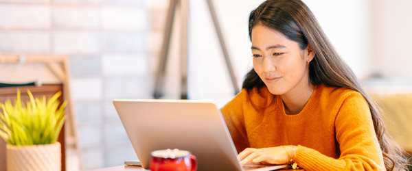 Woman typing on laptop smiling